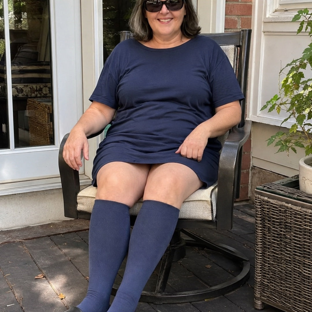 Donna sorridente in poltrona da giardino con calze a compressione blu Vitalis